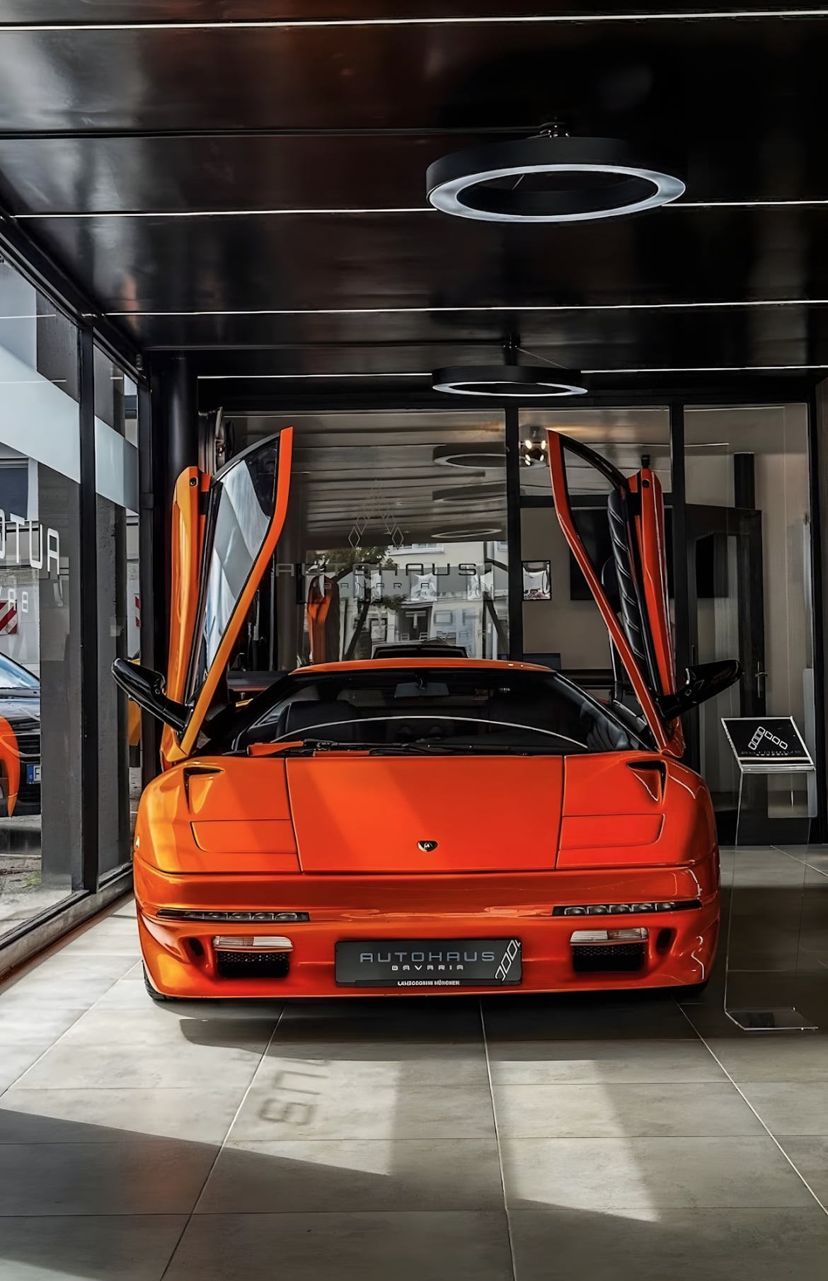 Oranger Lamborghini mit geöffneten Scherentüren im Showroom