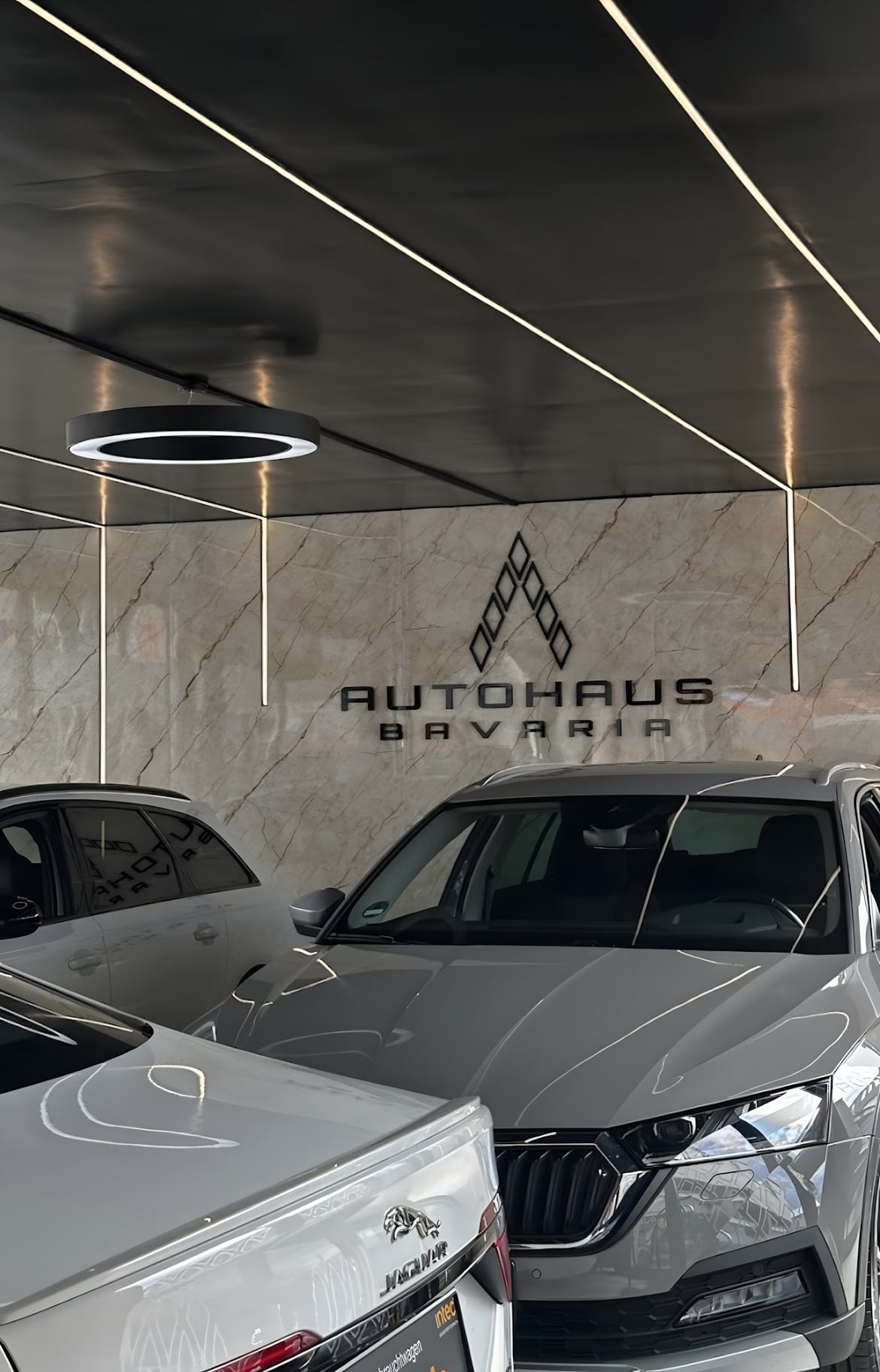 Autohaus-Bavaria-Logo auf einer Marmorwand im Showroom